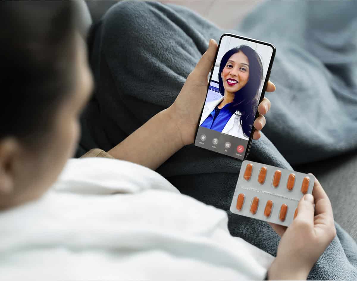 Patient on a video call with a dentist while holding medication